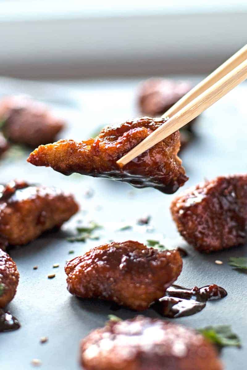 crispy garlic chicken piece in chopsticks