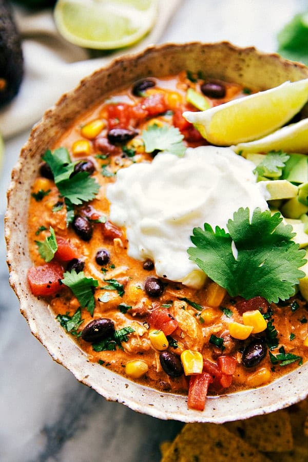 crockpot enchilada chili up close with sour cream cilantro and lime wedges