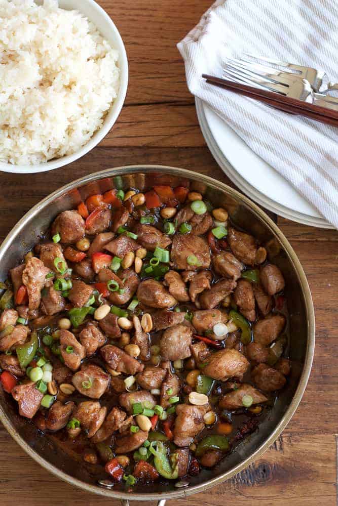 kung pao chicken in skillet with peanuts and green onions