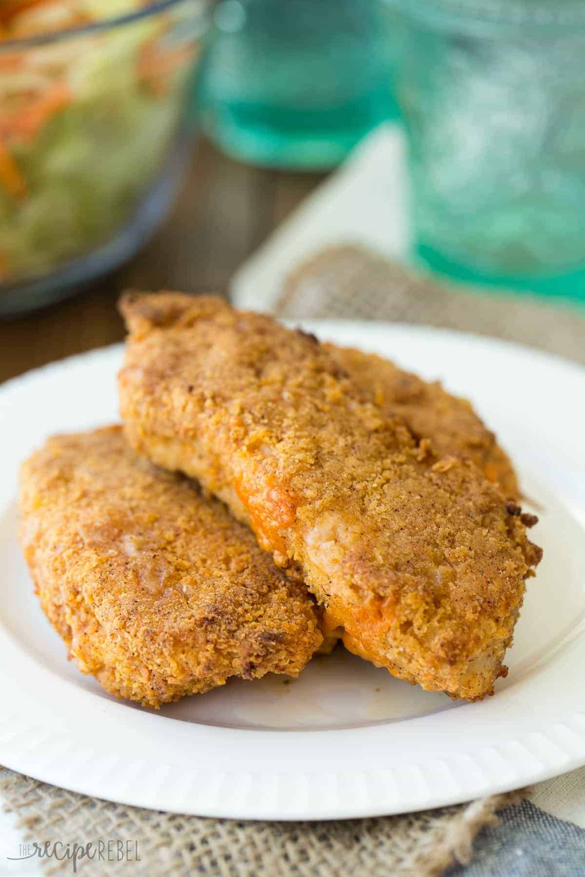 two pieces of oven fried nacho cheese stuffed chicken on white plate