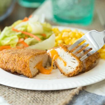 This Nacho Cheese Stuffed Oven Fried Chicken is stuffed with cheddar cheese and coated in a (from scratch -- no weird ingredients!) nacho flavored coating, and then oven fried to crispy perfection!