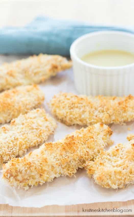 parmesan crusted chicken fingers on a sheet pan lined with parchment