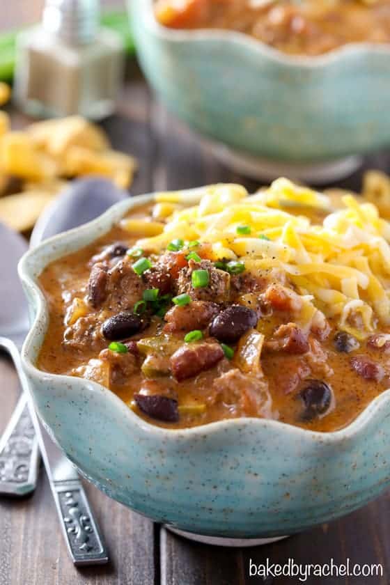 slow cooker cheesy beef nacho chili in a bowl topped with shredded cheese and chives
