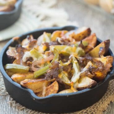 Seasoned crispy potato wedges topped with sauteed peppers, onions, roast beef and cheese -- these Philly Cheesesteak Potato Wedges are the perfect appetizer (or meal in one!) for your next game day or get together!
