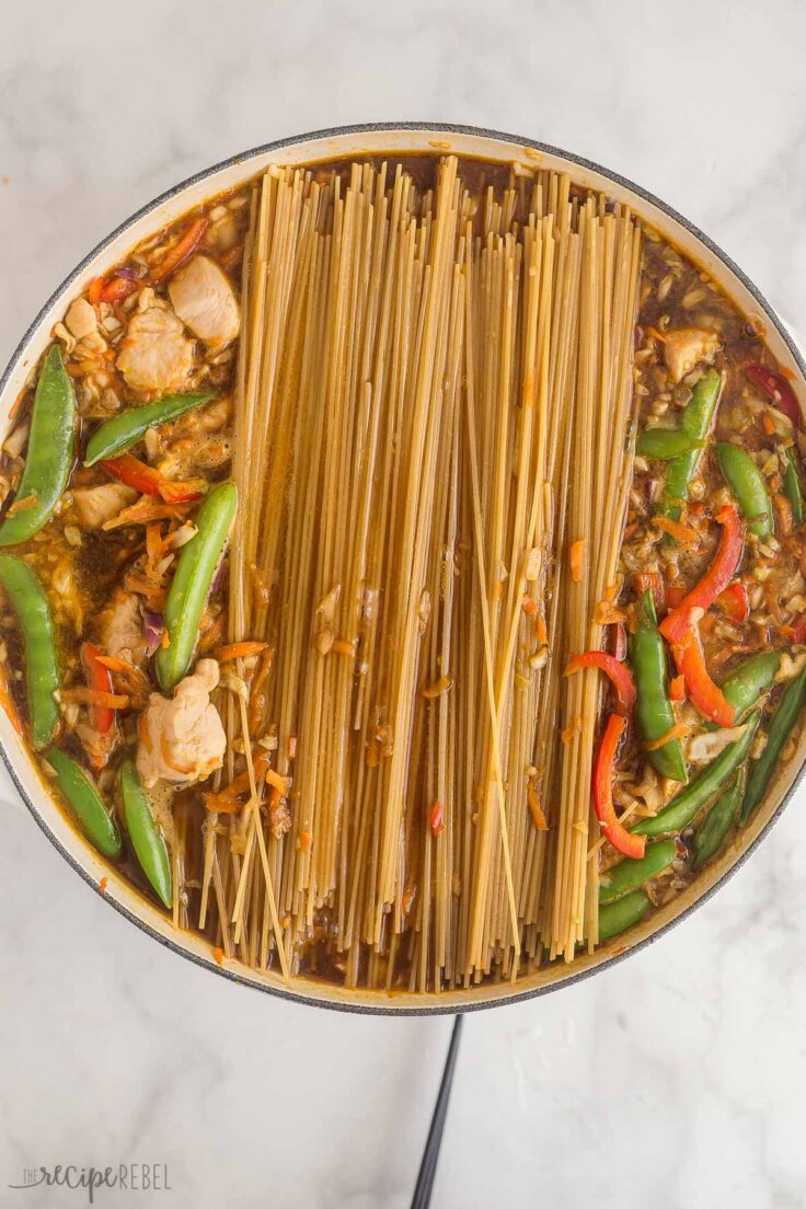 spaghettini noodles added to sauce in skillet for chicken chow mein