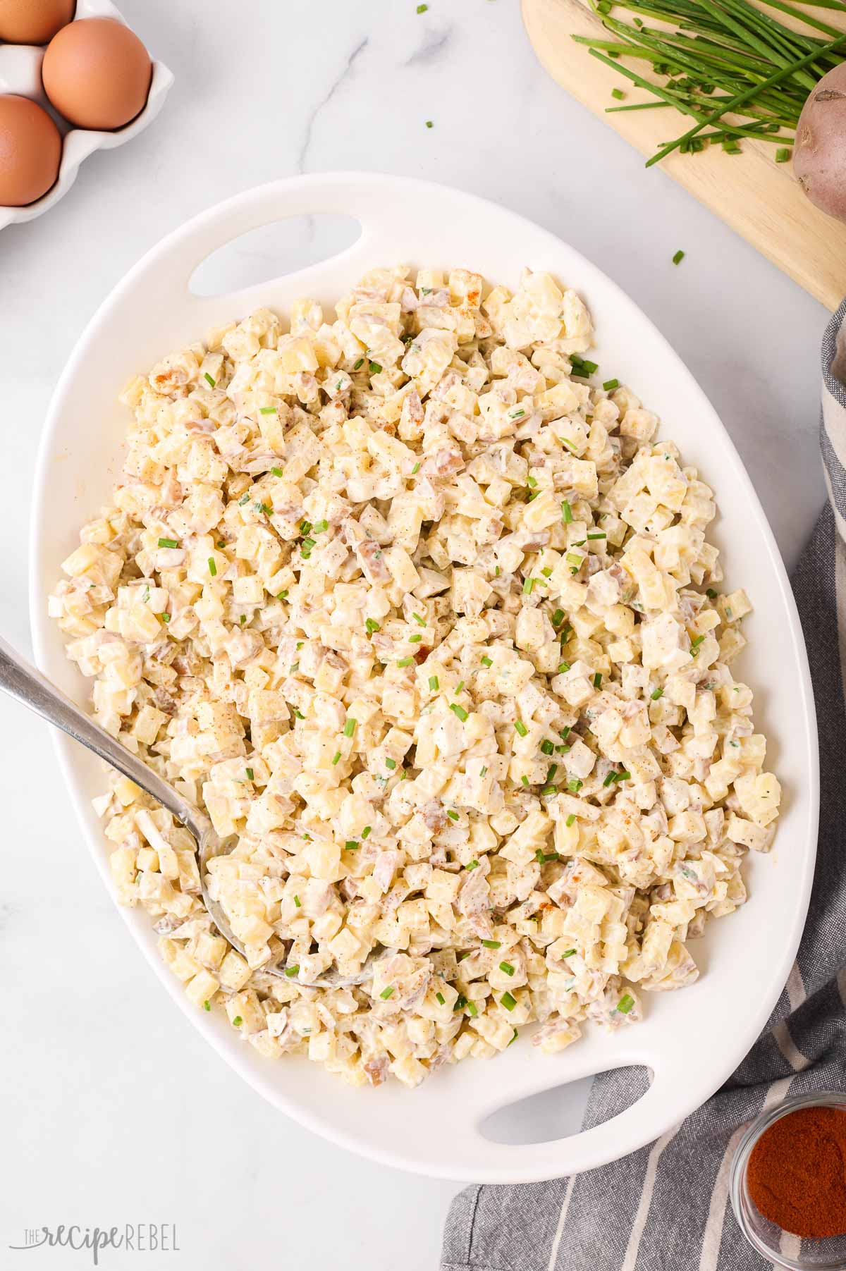 Simple, flavourful, and well-balanced, this Easy Potato Salad Recipe is made with red potatoes, hard-boiled eggs, and a tangy, savory mayonnaise dressing. Perfect for making ahead! #salad #bbq | bbq sides | barbecue sides | cold salads | make ahead salad | summer salad | side dish recipes overhead image of potato salad in large white serving bowl