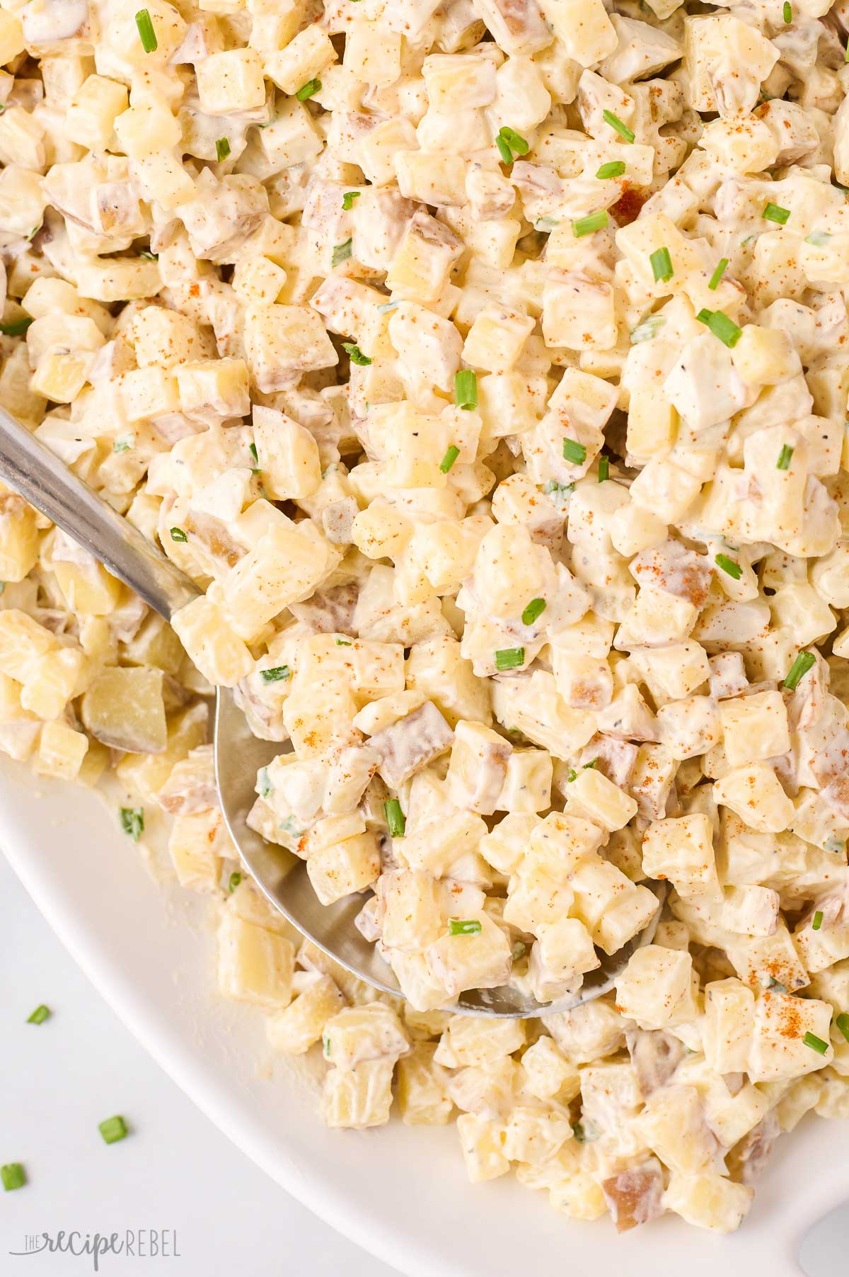 close up image of spoon stuck in potato salad