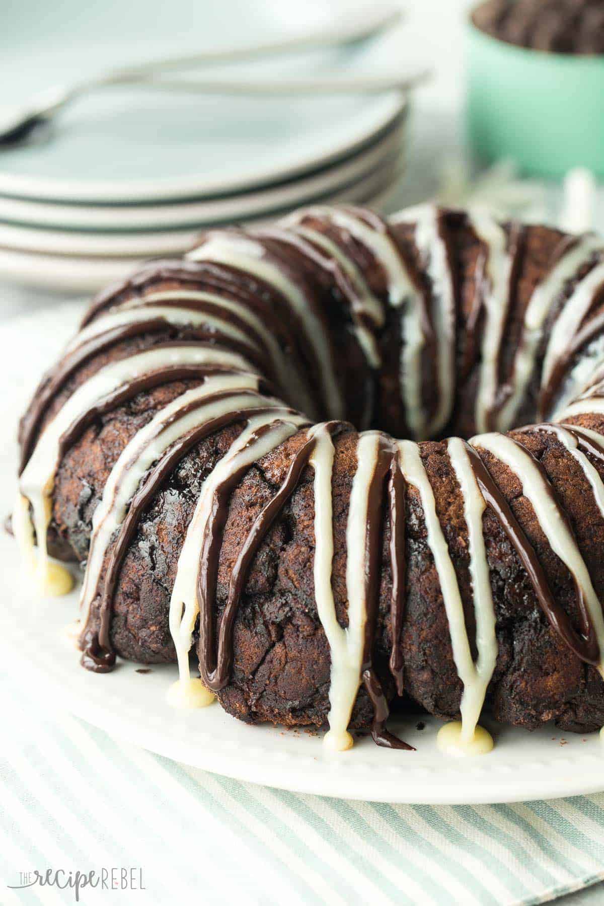 chocolate monkey bread on white plate with chocolate and white chocolate glaze