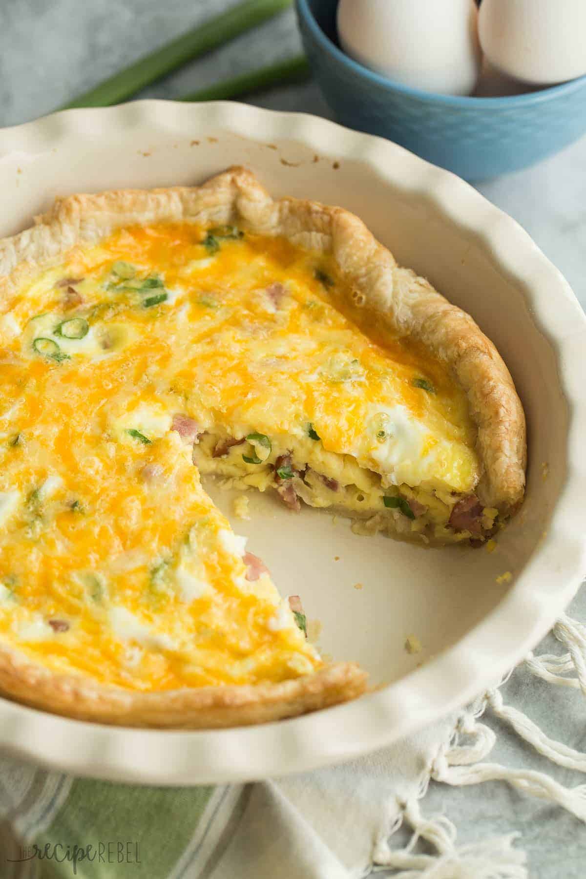 puff pastry quiche in pie plate with one piece cut out