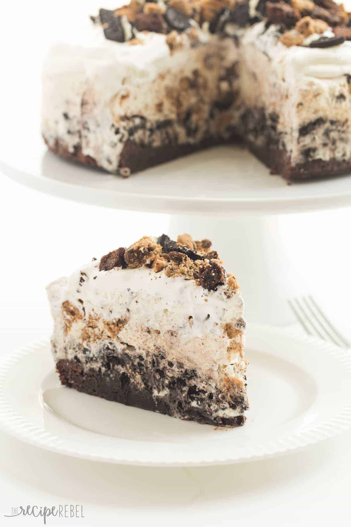 piece of chocolate chip cookie brownie oreo ice cream cake on white plate in front of whole cake