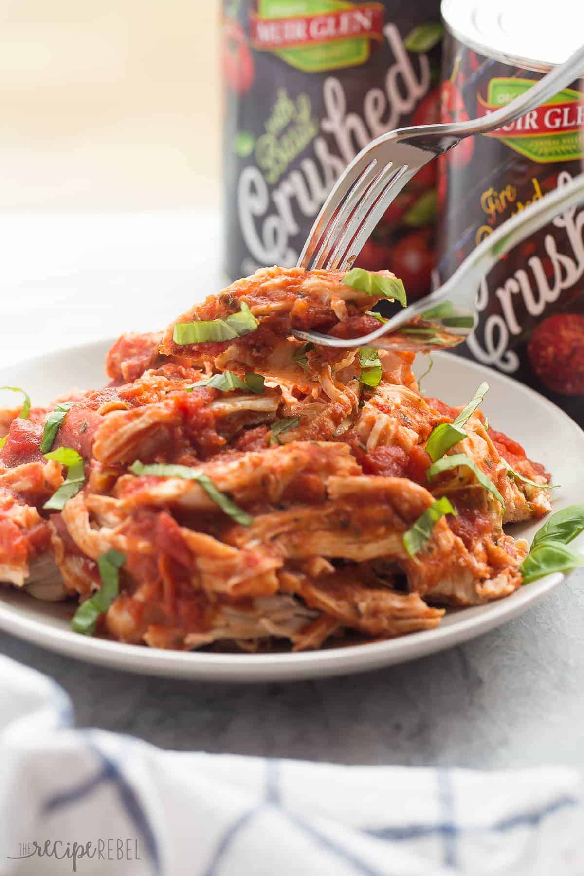 shredded italian tomato chicken breasts on a plate with Muir Glen tomato cans behind