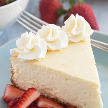 This Vanilla Cheesecake is super creamy and not as heavy as traditional baked cheesecake thanks to a good dose of sour cream or Greek yogurt -- it's soft and luscious and perfect with fresh berries!