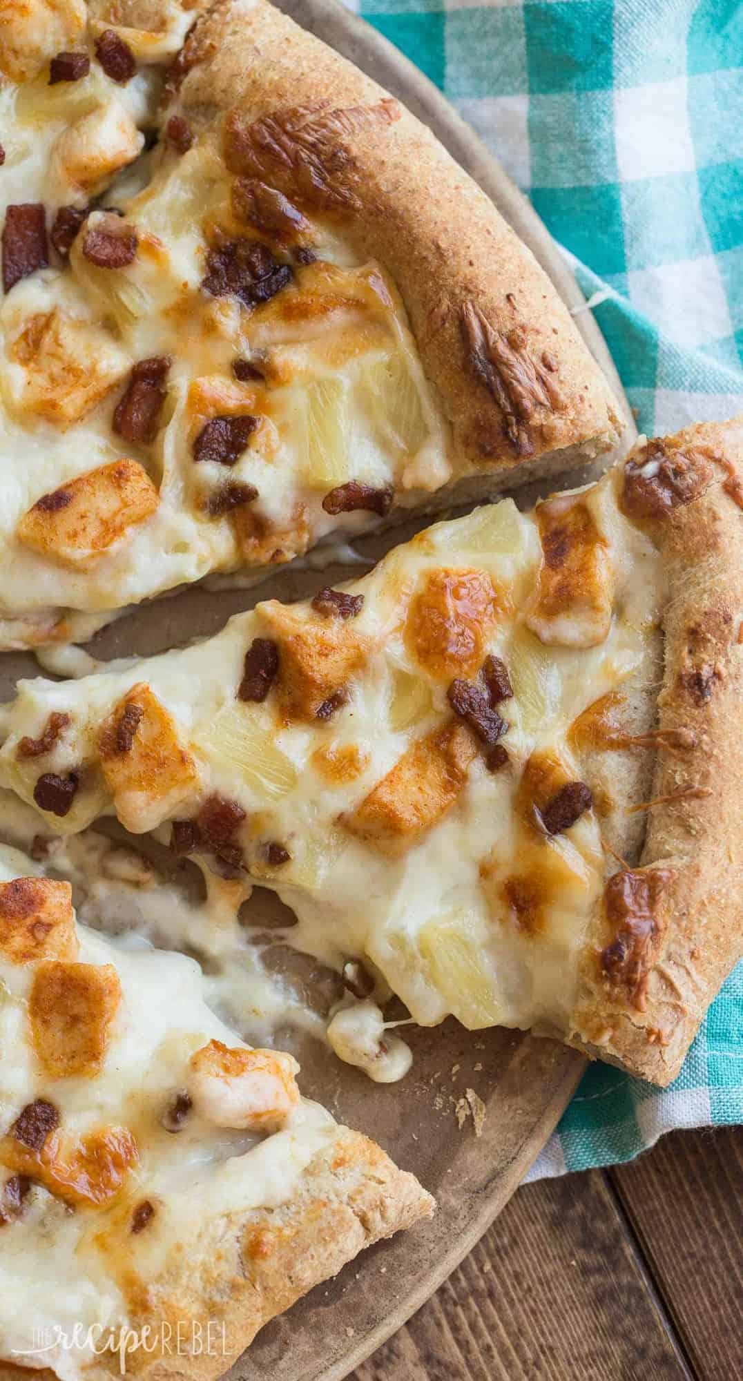 close up overhead image of tropical chicken pizza with one slice being removed