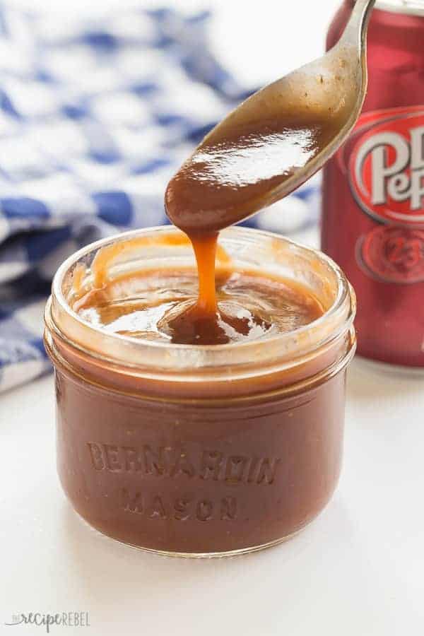 small jar of dr pepper bbq sauce with spoon scoop and drizzling sauce in jar