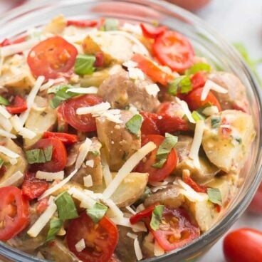 A fun new twist on classic Potato Salad! This Creamy Italian Potato Salad is filled with spinach, pesto, tomatoes, roasted red peppers and Parmesan cheese, it's perfect alongside grilled chicken or at any picnic!