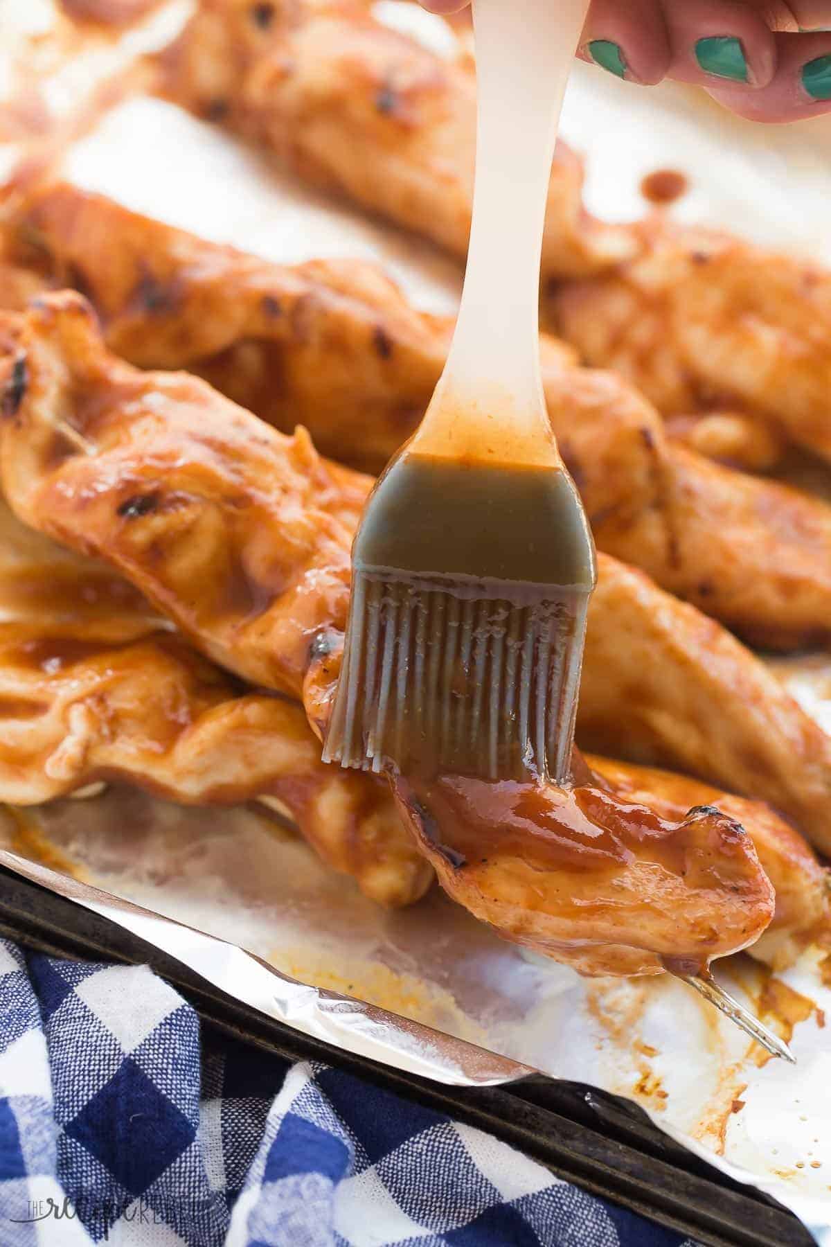 pastry brush brushing dr pepper barbecue sauce on chicken skewers