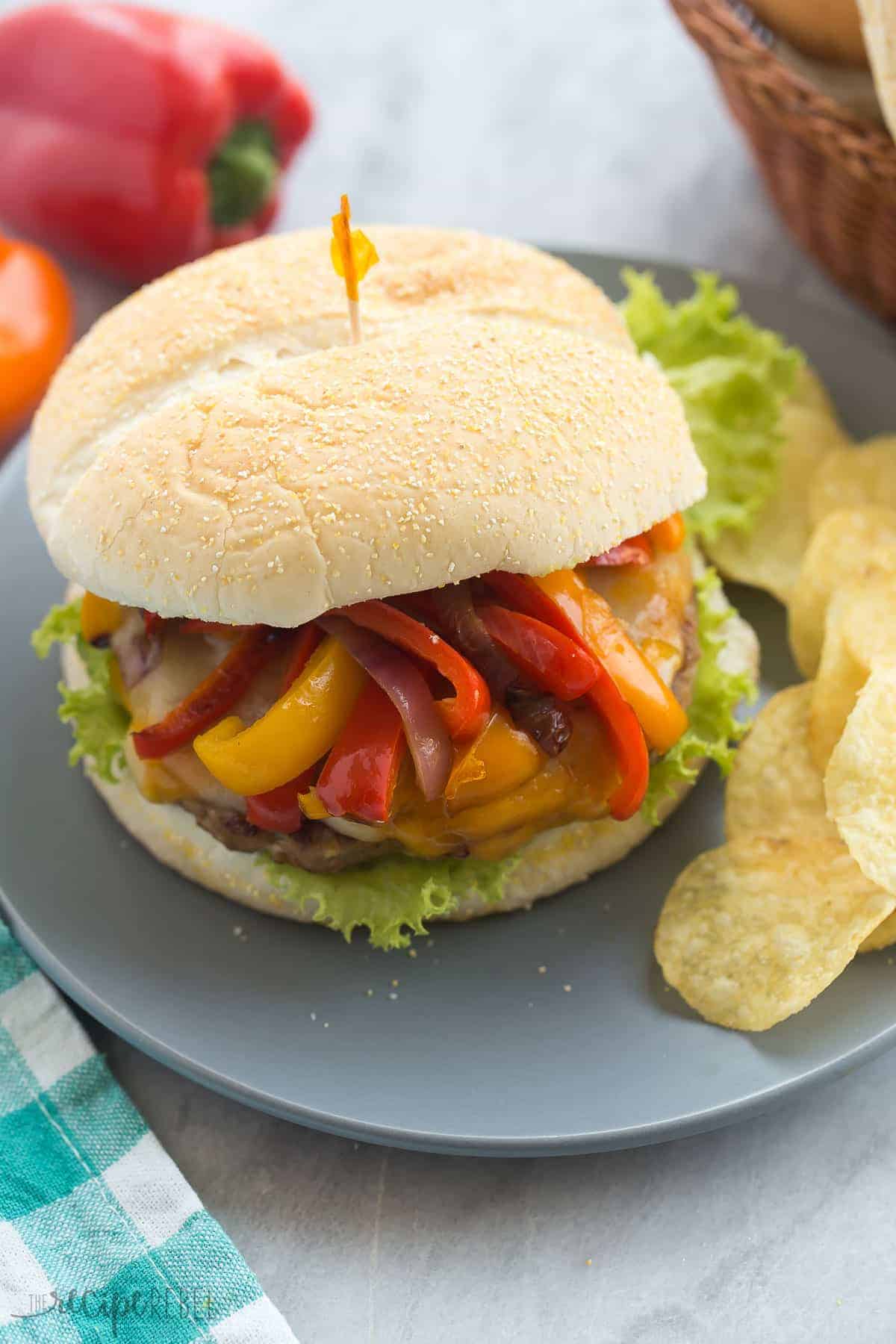 fajita turkey burger with sauteed peppers on grey plate with chips