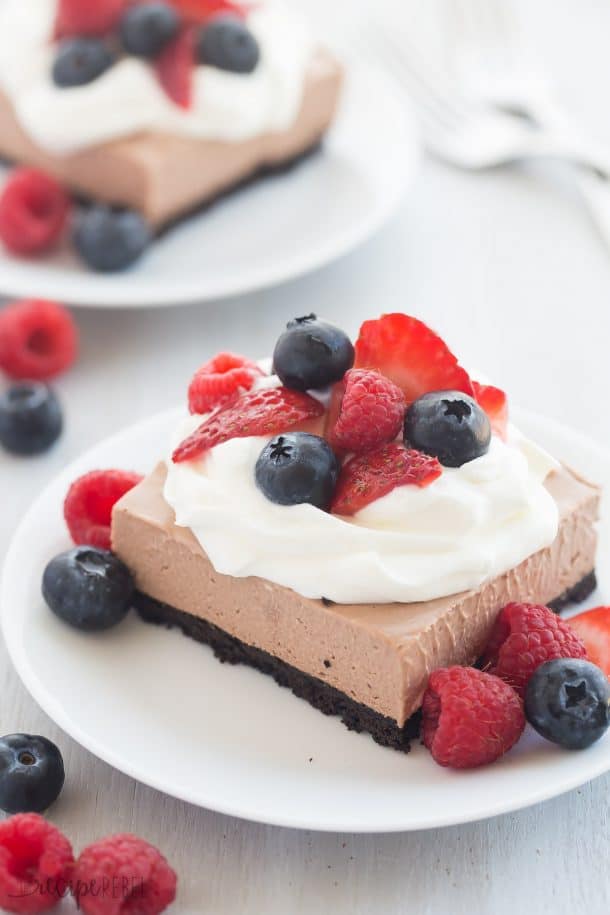 no bake chocolate nutella cheesecake bars with whipped cream and fresh berries on top