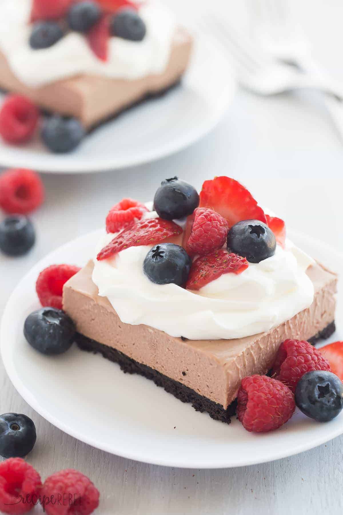 square of nutella cheesecake bars on small white plate with fresh berries