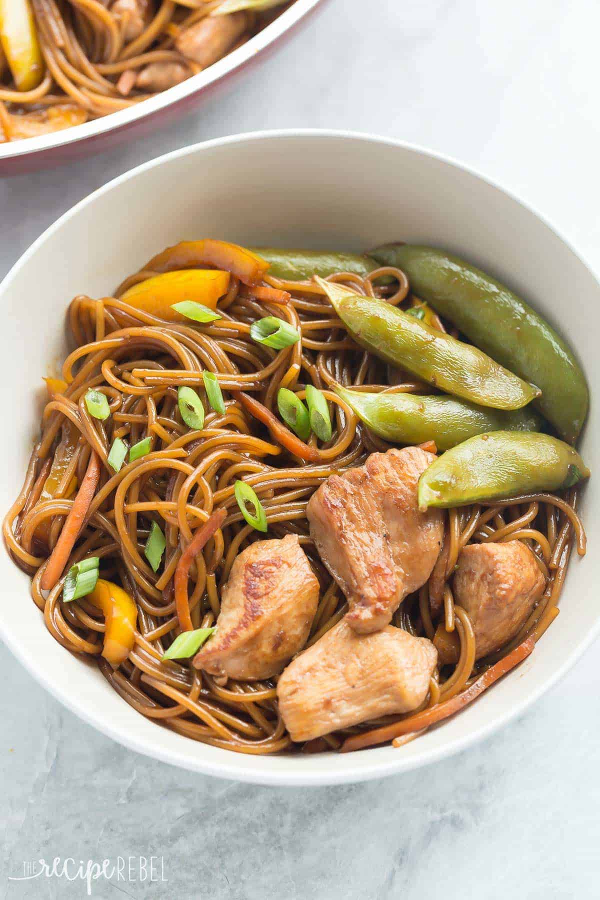white bowl with teriyaki chicken snap peas peppers and noodles