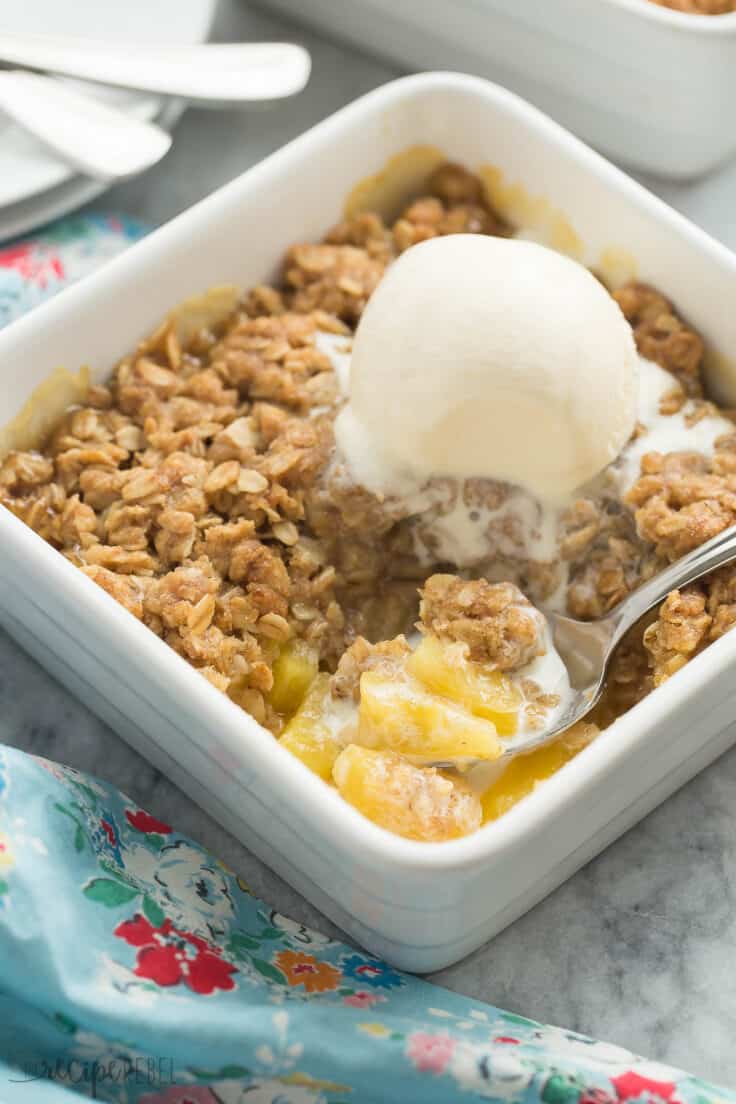 pineapple crisp in square white individual baking dish with scoop of ice cream
