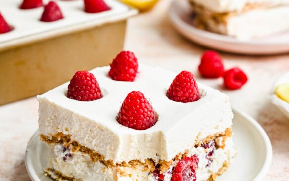 two pieces of lemon icebox cake on plates with pan in the background.