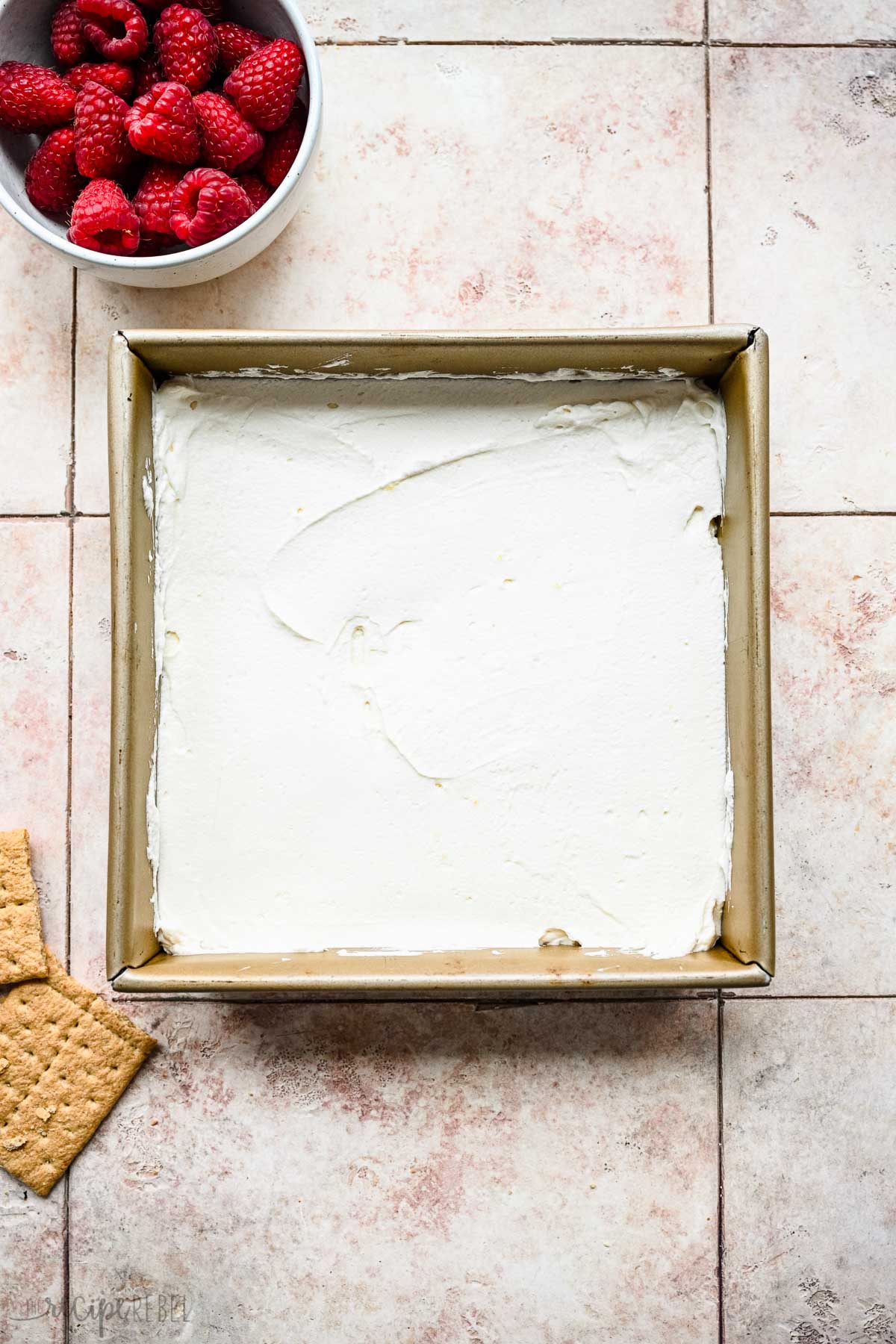 whipped cream on top of graham crackers in square pan.