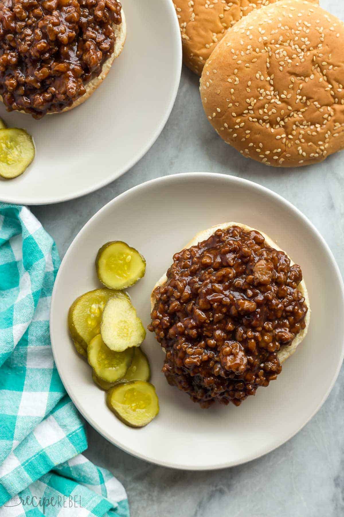 overhead image of honey garlic turkey sloppy joes open faced on grey plate with pickles
