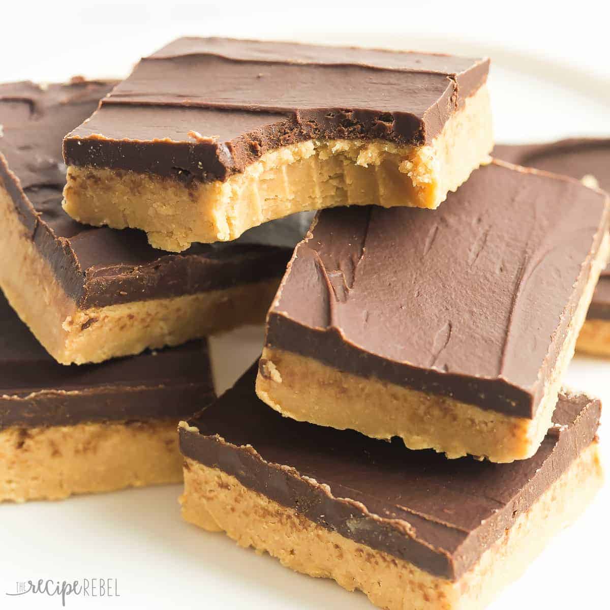 stack of no bake chocolate peanut butter bars with bite taken out of top bar