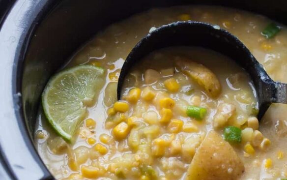 slow cooker potato corn chowder with jalapeno in crockpot with ladle