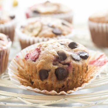 These Chocolate Chip Banana Muffins are the best -- so moist but made healthier with whole wheat flour, yogurt and loaded with fresh strawberries!