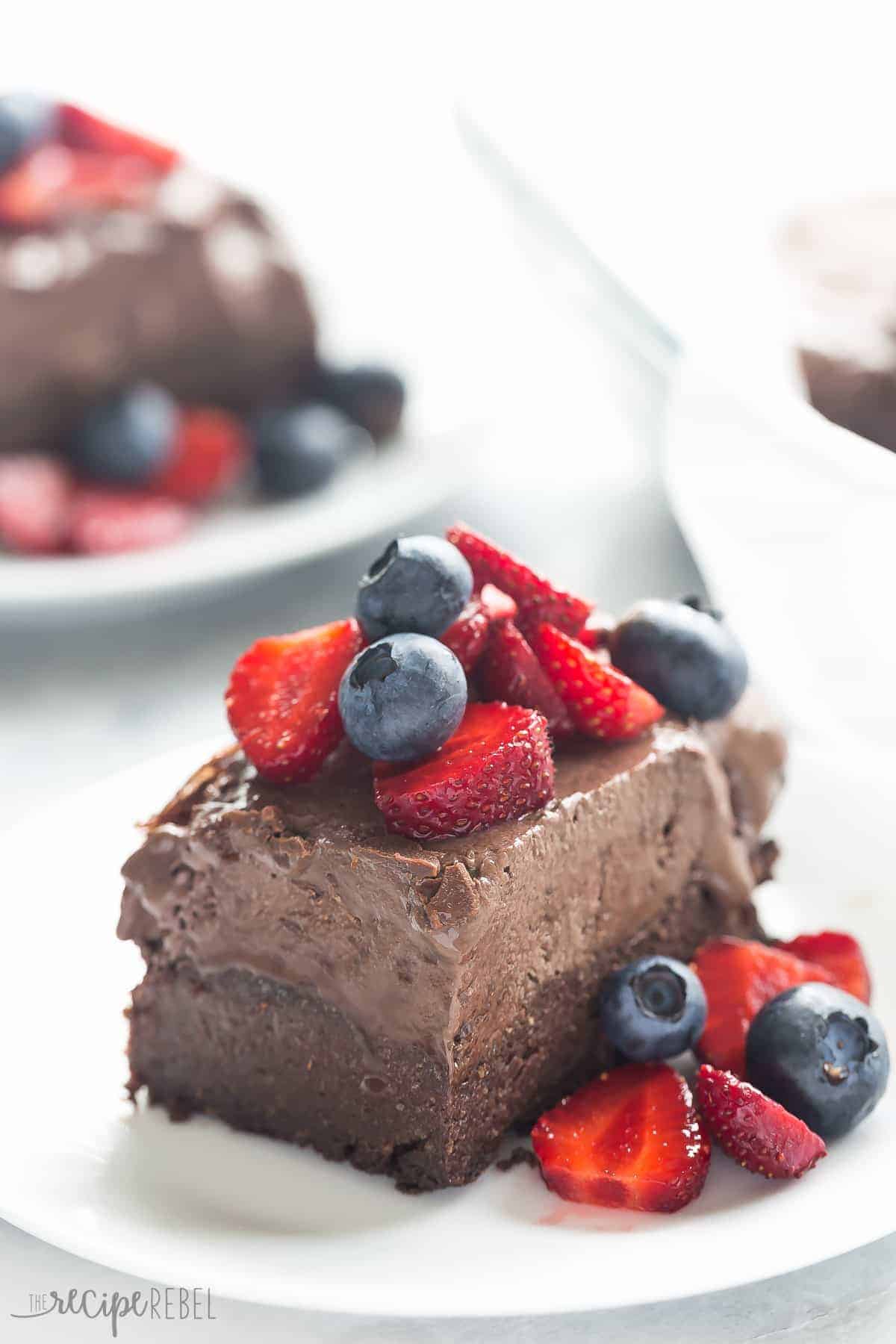 slice of frozen chocolate truffle brownie bars with fresh strawberries and blueberries on top