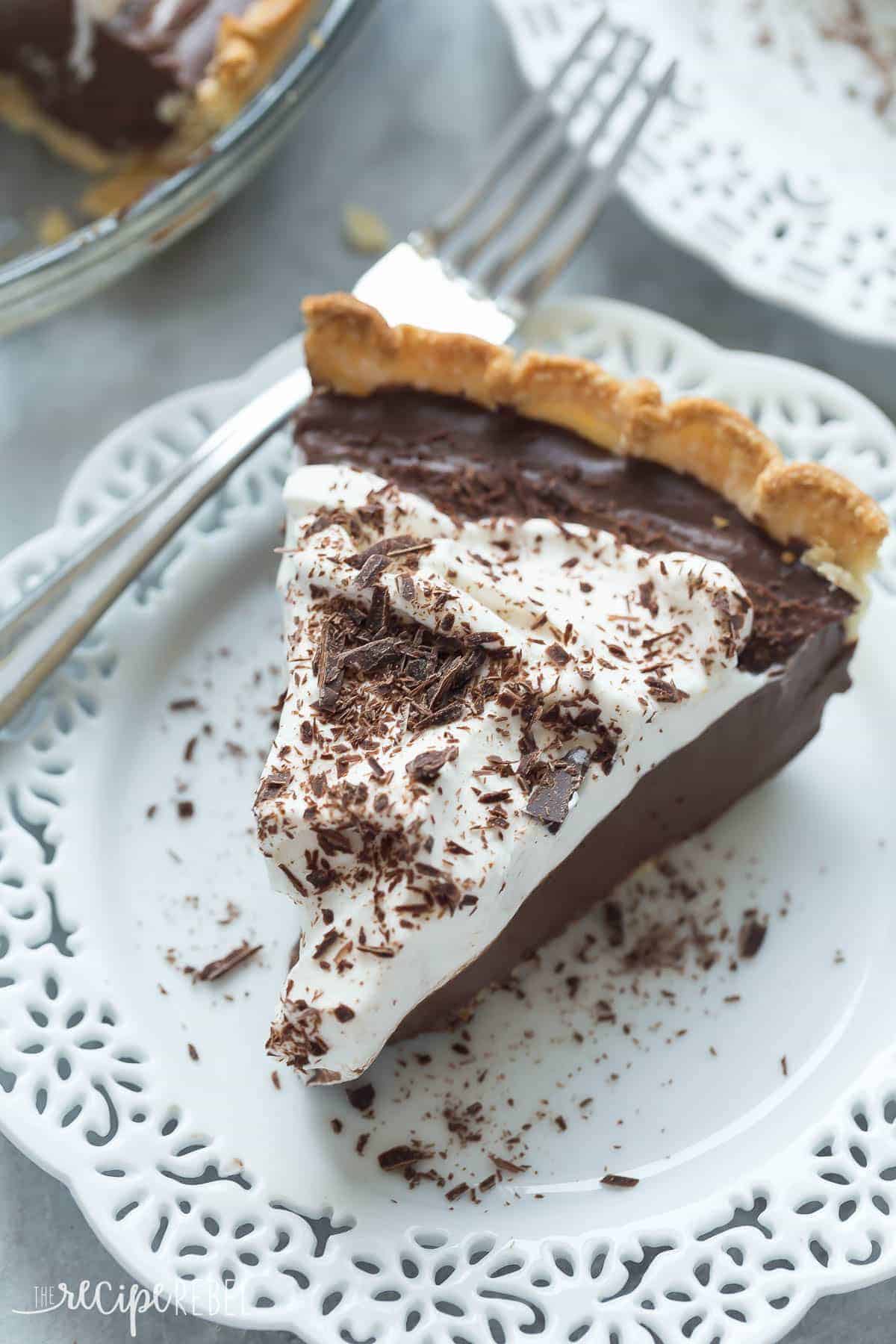 This Homemade Dark Chocolate Pudding Pie is the dessert for chocolate lovers! It is rich, smooth, creamy and made from scratch -- perfect for your holiday dessert table! piece of homemade chocolate pudding pie with whipped cream and chocolate shavings