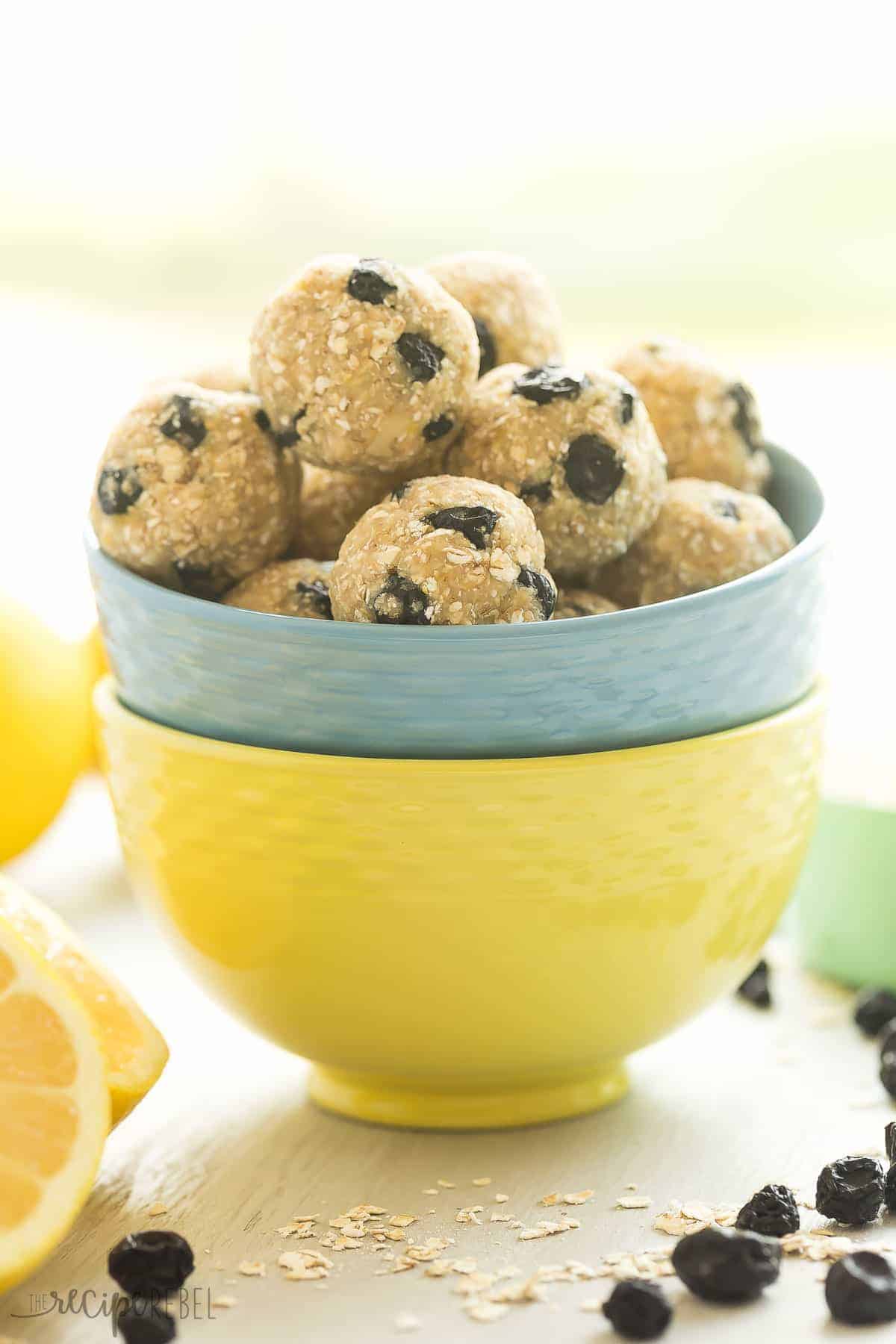 lemon blueberry energy bites in a blue bowl stacked in a yellow bowl