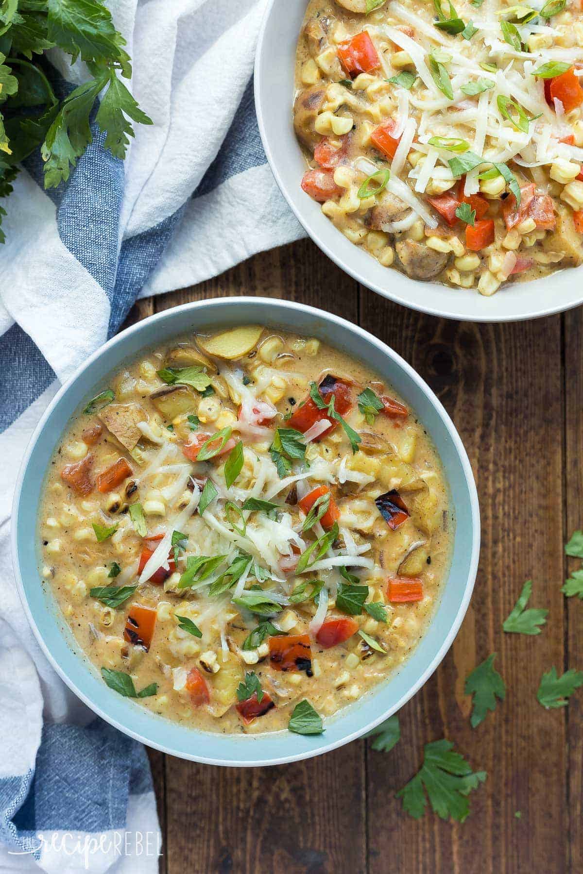 southwestern potato corn chowder in two bowls topped with shredded cheese and green onions