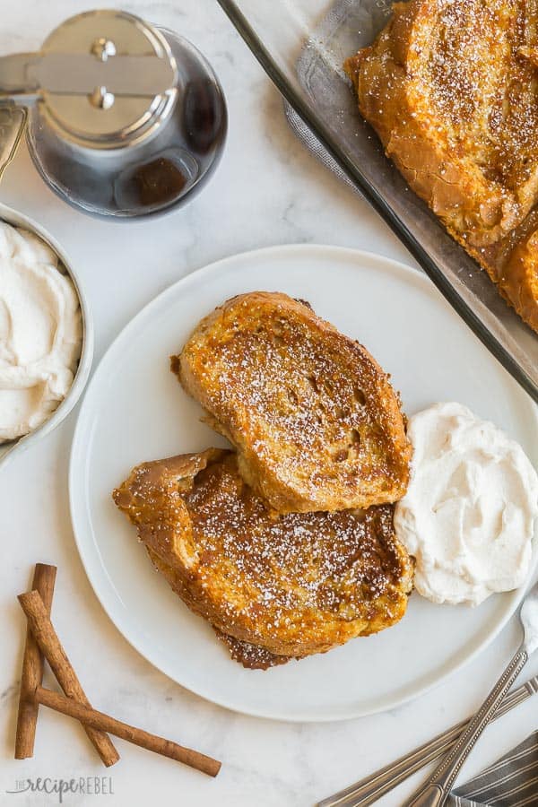 pumpkin french toast two slices on white plate overhead with whipped cream on plate