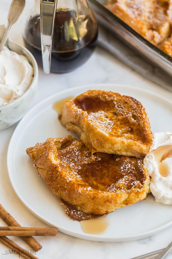 two pieces of pumpkin french toast with syrup on white plate