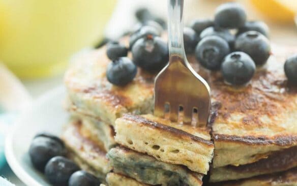These Lemon Blueberry Greek Yogurt Pancakes are light, fluffy and made healthier with whole wheat flour! They're loaded with blueberries and pack a punch of citrus flavor!