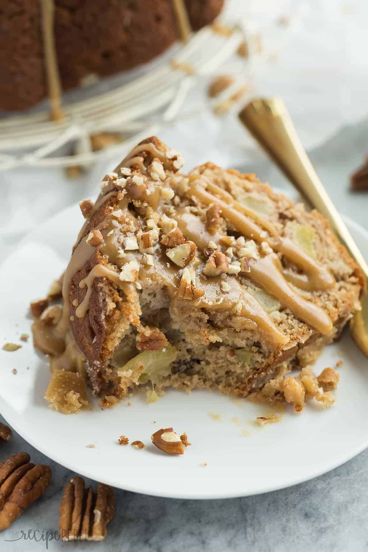 praline glazed apple bundt cake on white plate with gold fork and bite taken out