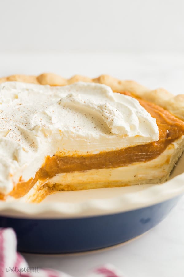 cream cheese pumpkin pie cut with pieces removed in blue pie plate