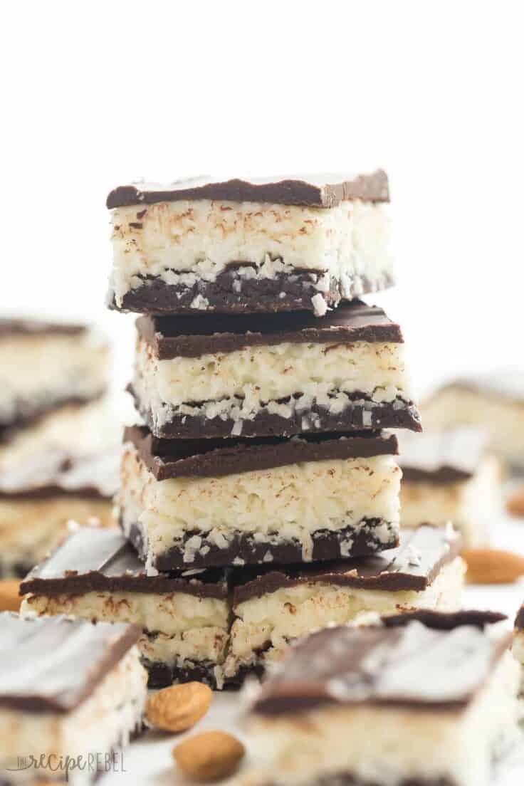 These Almond Joy Brownies have a thin, fudgy brownie layer and are topped with a creamy coconut filling, almonds and a layer of chocolate! They are an easy treat for the holidays! Delicious Almond Joy brownies stacked on top of each other.