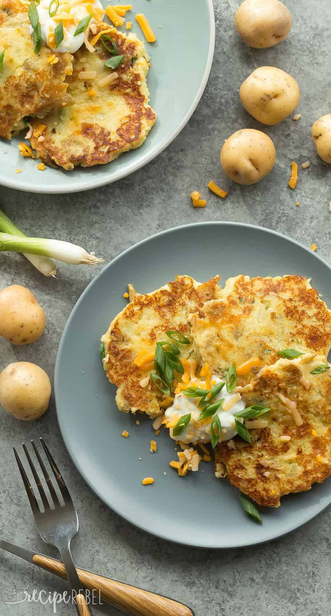 overhead image of mashed potato pancakes on grey plate with sour cream and green onions