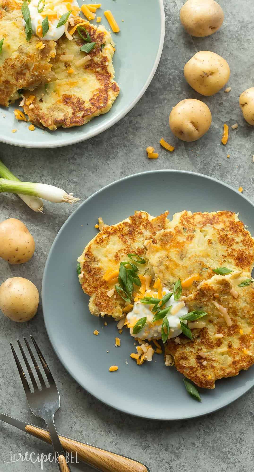 These Cheesy Mashed Potato Pancakes are one of the best ways to use up leftover mashed potatoes! Just 5 ingredients and a few minutes prep. overhead image of mashed potato pancakes on grey plate with sour cream and green onions