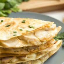 Chicken Alfredo quesadillas stacked on a gray-blue plate.