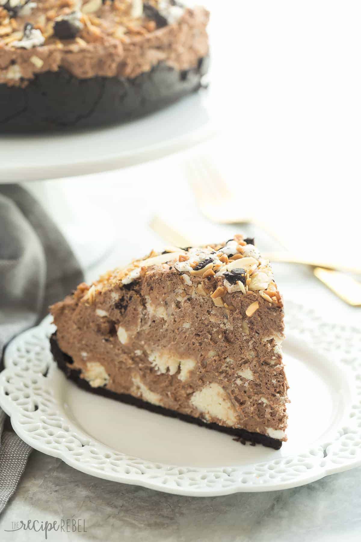 slice of chocolate explosion cake on white plate with visible cheesecake chunks