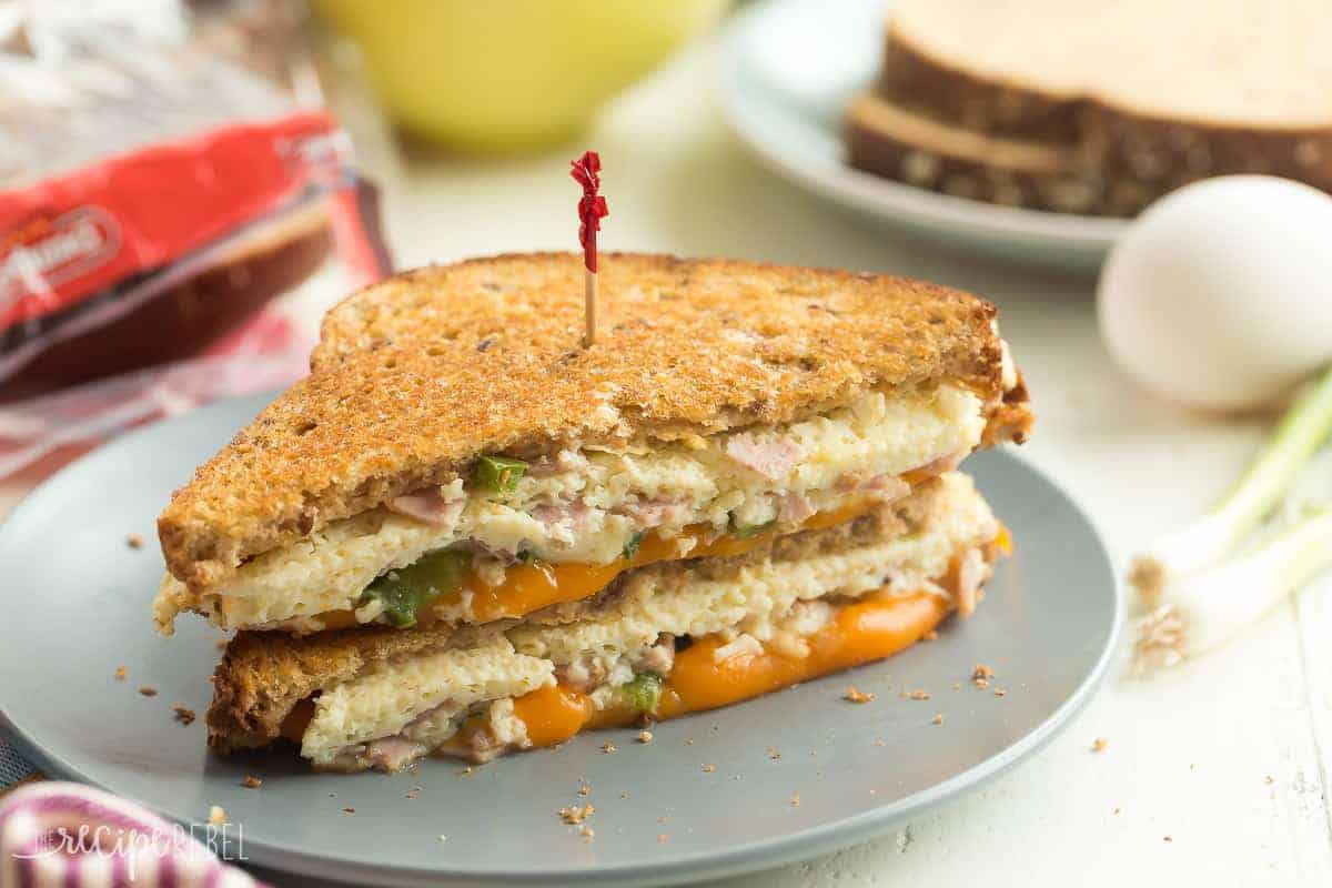 Denver grilled cheese sandwich stacked on a grey plate with toothpick stuck in the top.