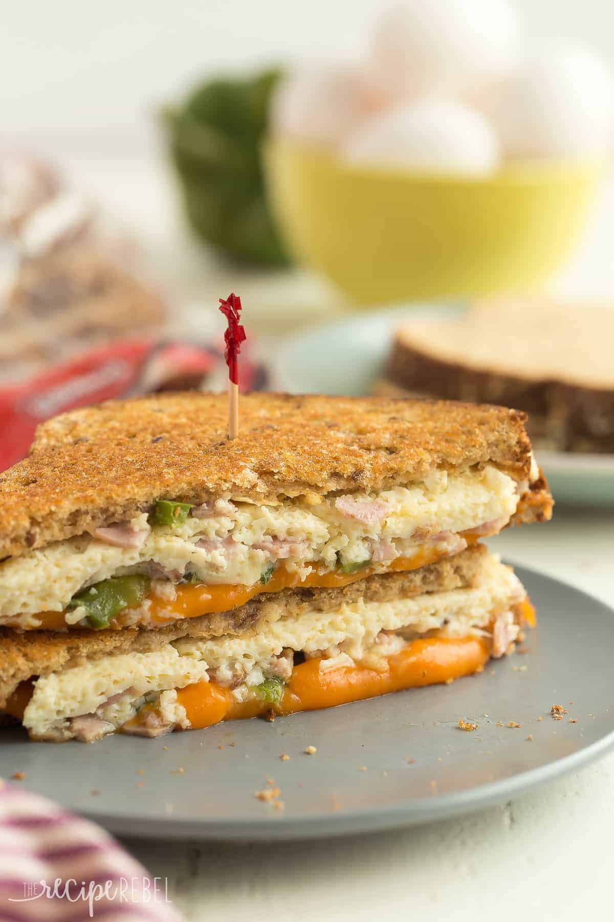 denver grilled cheese sandwich stacked on a grey plate with toothpick stuck in the top