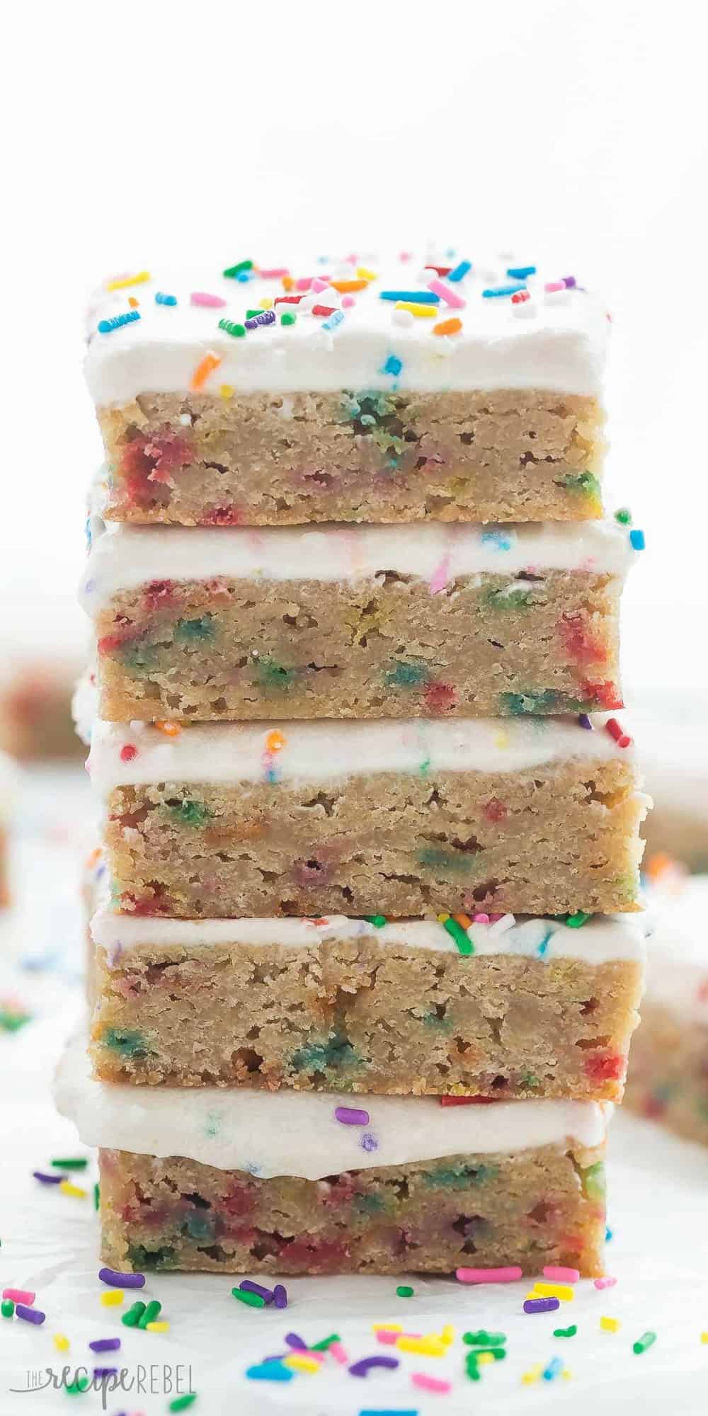 tall stack of frosted funfetti blondies with lots of sprinkles on white background