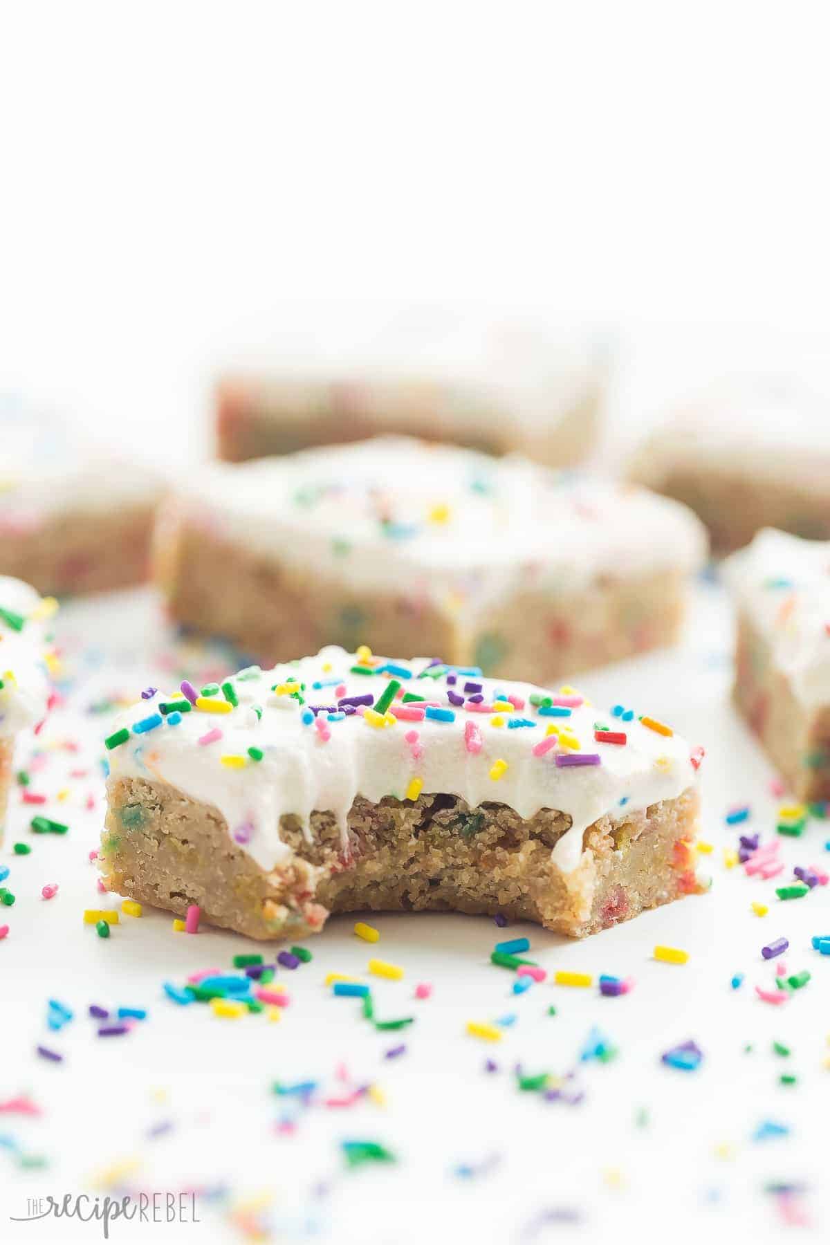 one square of funfetti blondies up close with more in the background and sprinkles all around