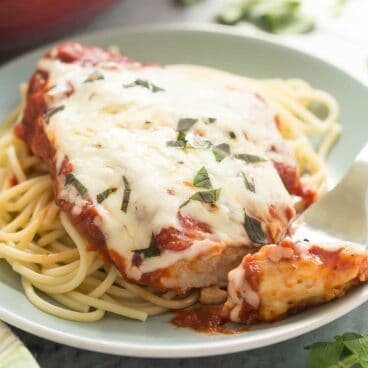This Skillet Chicken Parmesan is made healthier with a homemade tomato sauce, skinless chicken breasts and no breading or frying (which means it's also gluten free)! It's a 30 minute meal that everyone will love!
